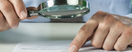 Man Reading With Magnifying Glass